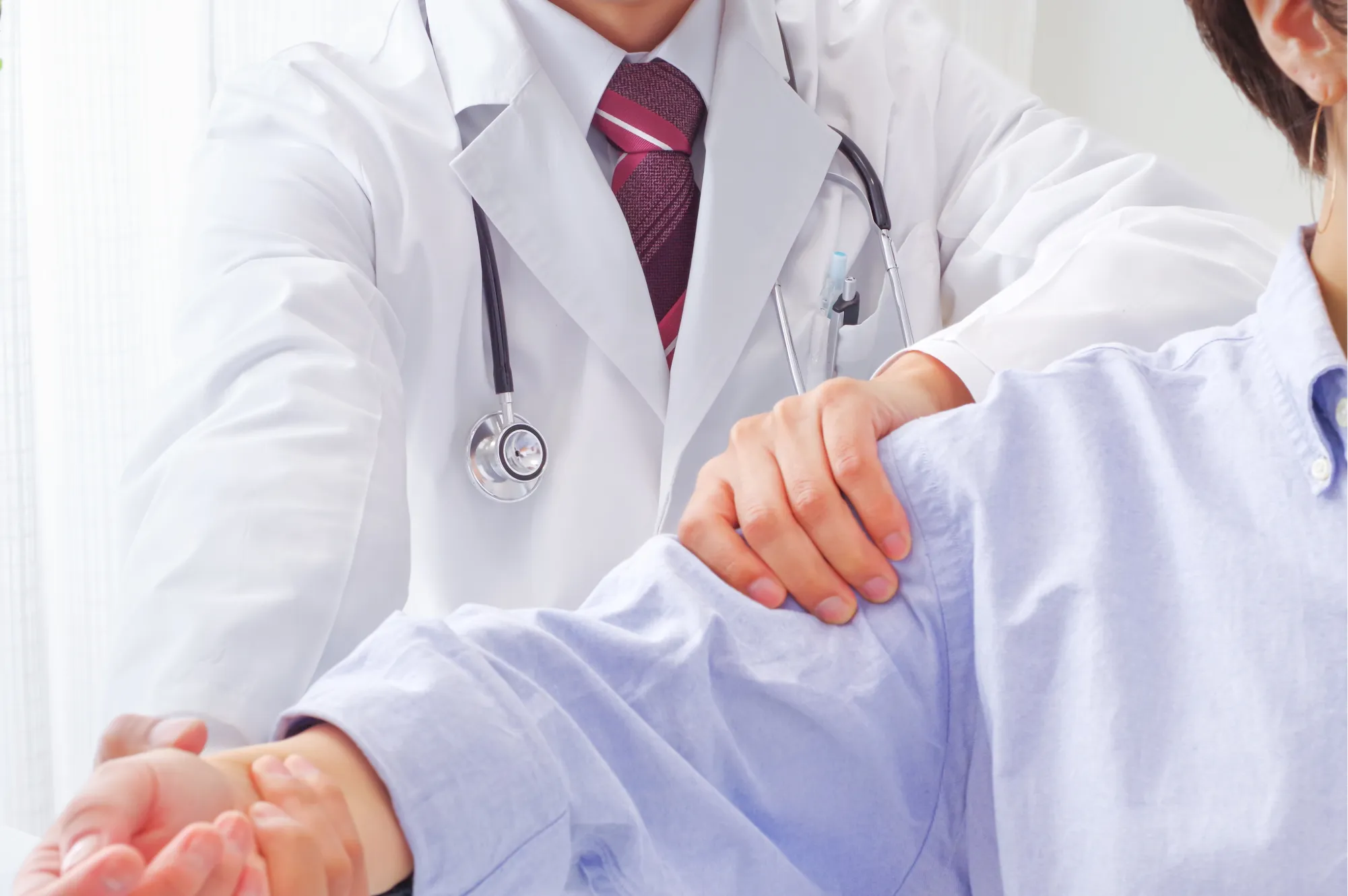 Doctor examining a patient's shoulder to assess frozen shoulder