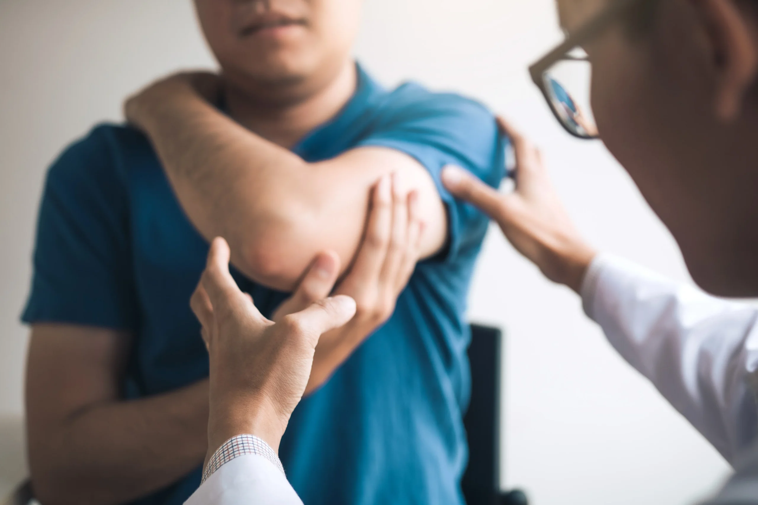 Orthopedic surgeon checking a patient’s elbow range of motion after an elbow dislocation