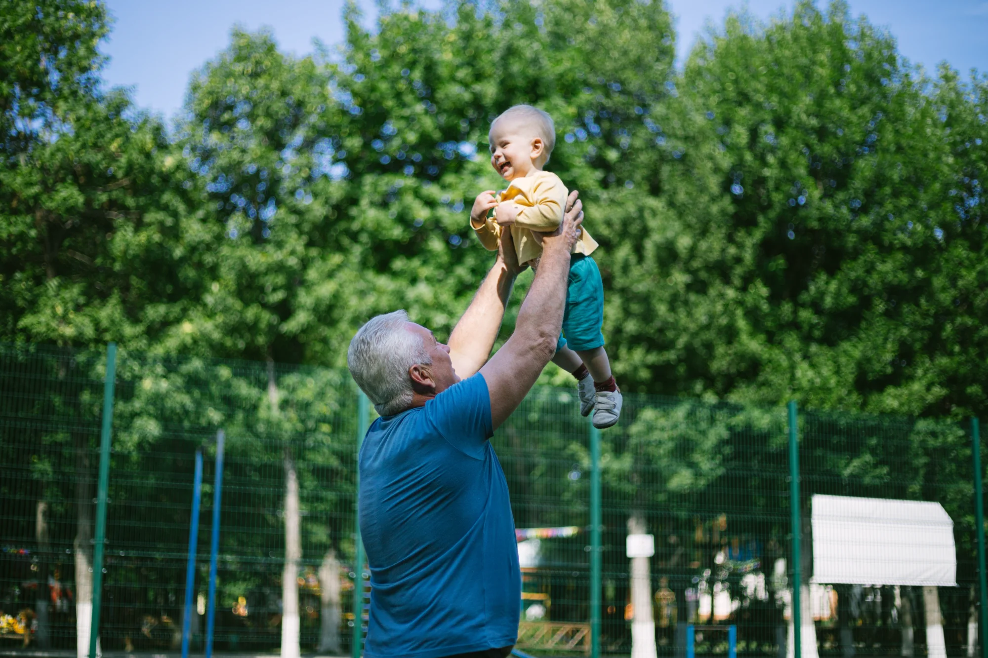 Grandpa picking up and holding his grandchild